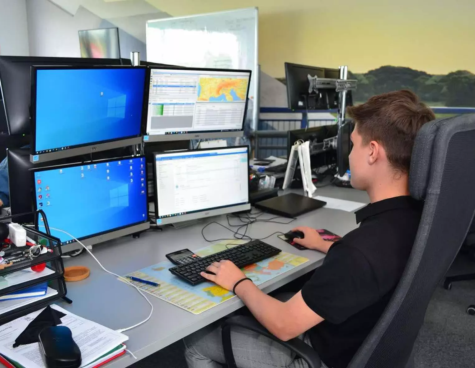 Uczeń siedzi przy komputerze i pracuje na programie do spedycji Uczeń kierunku technik spedytor siedzi przy komputerze i pracuje na programie do spedycji